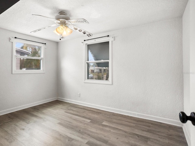 spare room featuring a ceiling fan, a textured ceiling, baseboards, and wood finished floors