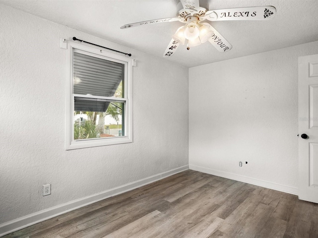 spare room with a textured wall, ceiling fan, baseboards, and wood finished floors