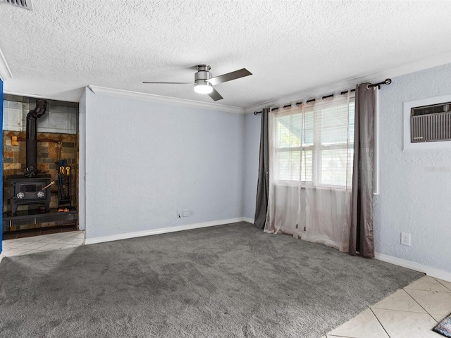 interior space with light colored carpet, a textured wall, a wood stove, ceiling fan, and a textured ceiling