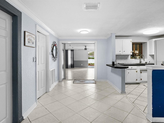kitchen featuring ornamental molding, dark countertops, visible vents, and white cabinets
