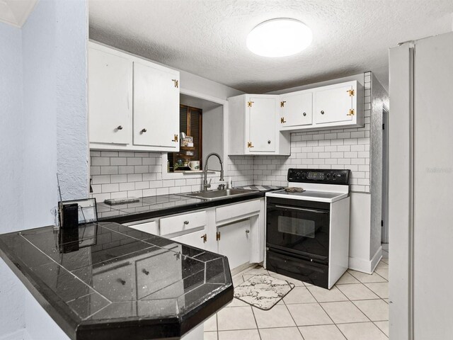 kitchen with a peninsula, dark countertops, black electric range, and white cabinetry