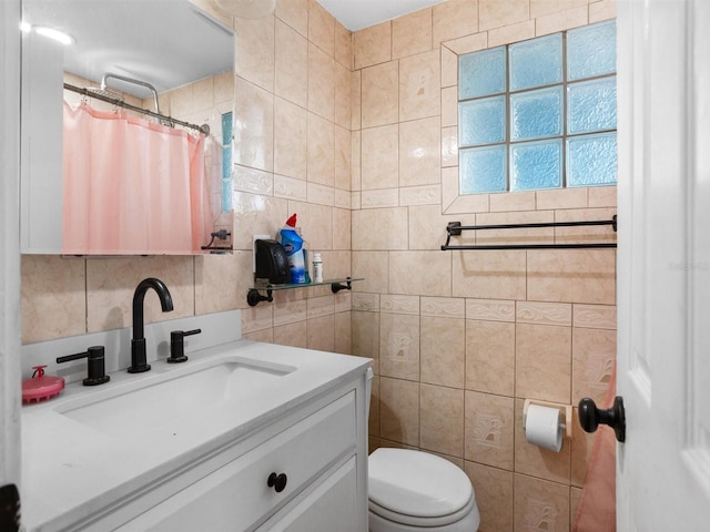 full bath featuring tile walls, decorative backsplash, a shower with shower curtain, toilet, and vanity