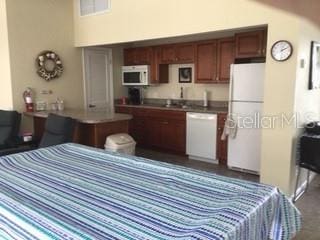 bedroom with white refrigerator and a towering ceiling