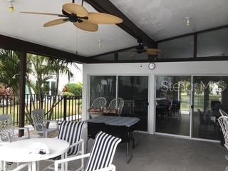 sunroom with ceiling fan, a healthy amount of sunlight, and lofted ceiling with beams