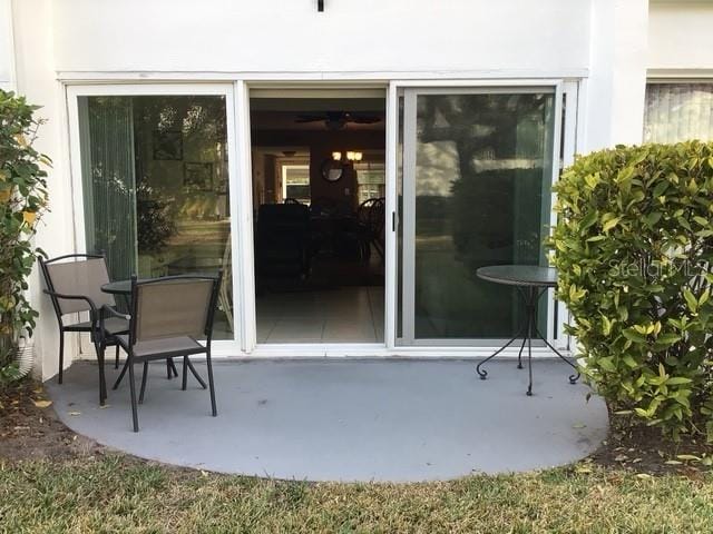 view of exterior entry with a patio area