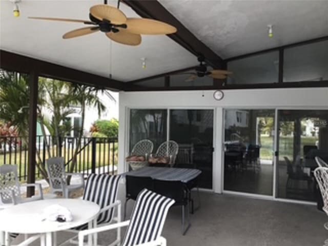 sunroom with vaulted ceiling with beams and ceiling fan