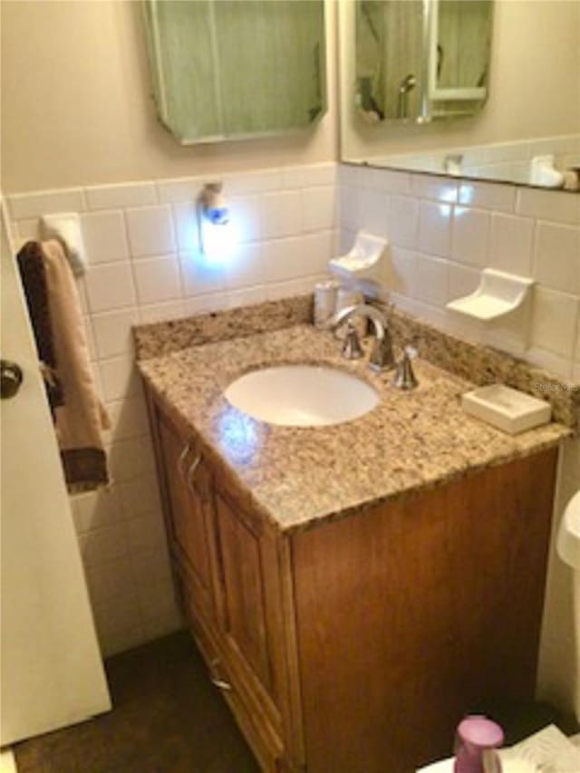 bathroom featuring vanity, tile walls, and a wainscoted wall