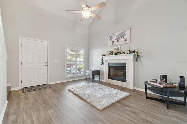 living room with hardwood / wood-style flooring, ceiling fan, and high vaulted ceiling