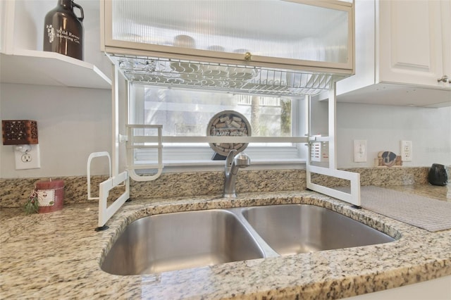 interior details featuring light stone countertops and sink