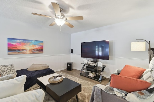 living room featuring hardwood / wood-style floors, a textured ceiling, and ceiling fan