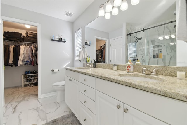 bathroom featuring vanity, toilet, and a shower with shower door