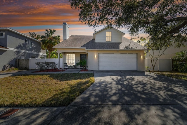 view of front of property with a garage and a lawn