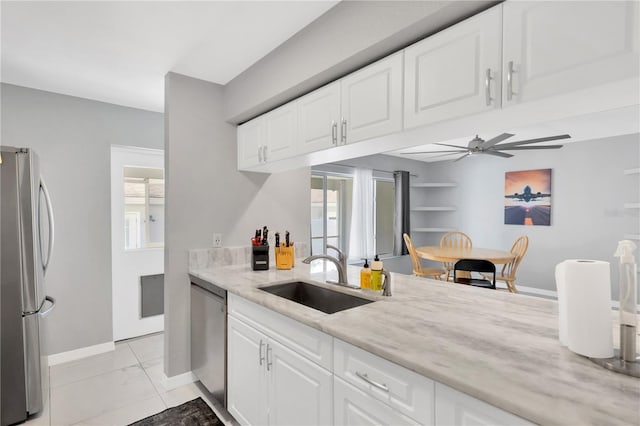 kitchen featuring sink, ceiling fan, appliances with stainless steel finishes, white cabinetry, and light stone countertops