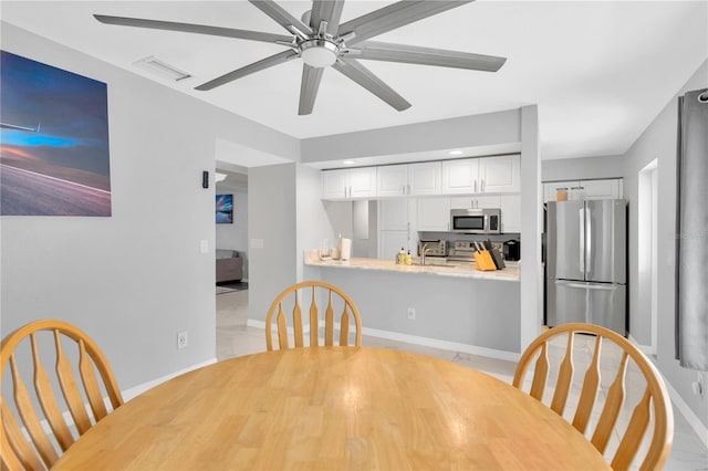 dining area featuring sink and ceiling fan