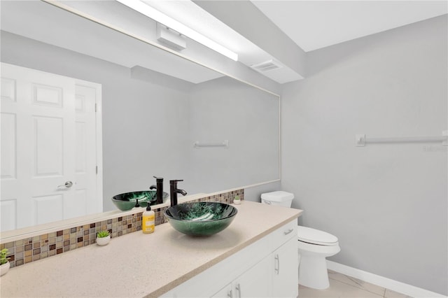 bathroom featuring vanity, toilet, and decorative backsplash