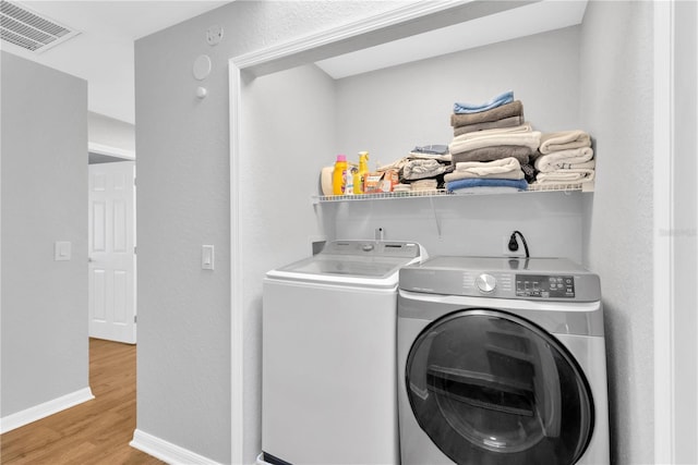 laundry room with separate washer and dryer and light wood-type flooring