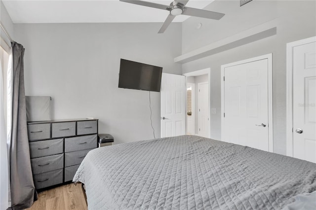 bedroom with hardwood / wood-style flooring, ceiling fan, and vaulted ceiling