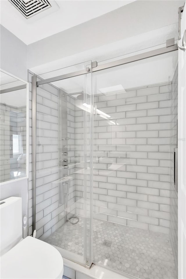 bathroom with an enclosed shower and toilet