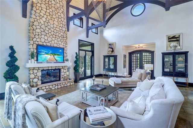 living room with a towering ceiling, a fireplace, and french doors