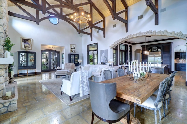 dining space with french doors, beamed ceiling, plenty of natural light, and a notable chandelier