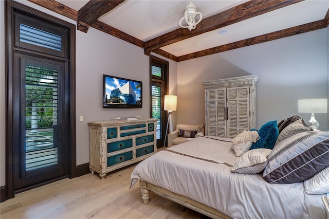 bedroom featuring access to exterior, beam ceiling, and light hardwood / wood-style flooring