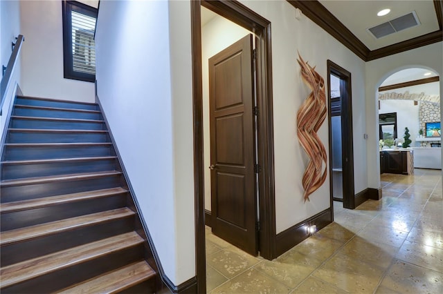 staircase featuring ornamental molding and a wealth of natural light