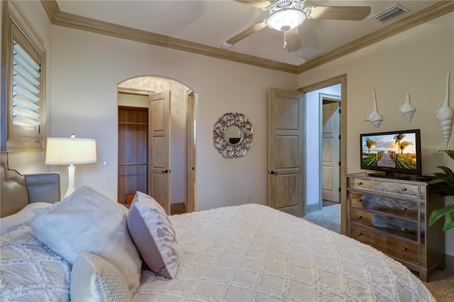 carpeted bedroom featuring ornamental molding, a closet, and ceiling fan