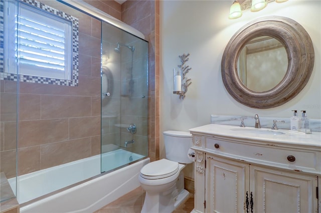 full bathroom with vanity, tile patterned flooring, shower / bath combination with glass door, and toilet