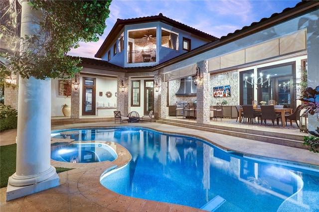 pool at dusk with an in ground hot tub, ceiling fan, and a patio