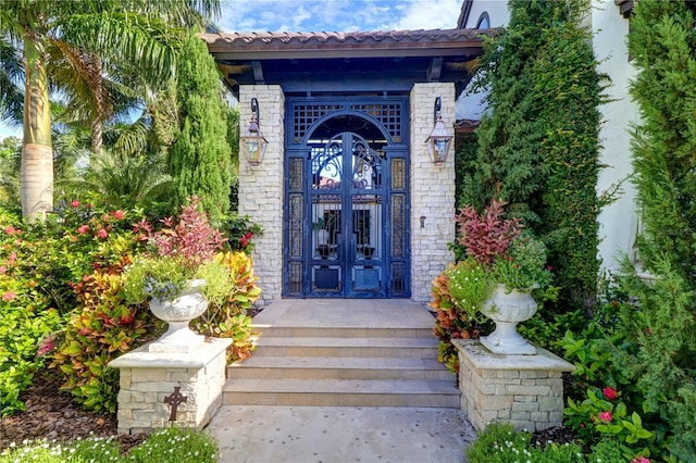 view of exterior entry featuring a tiled roof