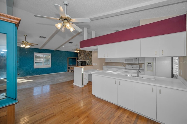 kitchen featuring white cabinetry, sink, vaulted ceiling with beams, white appliances, and light hardwood / wood-style flooring