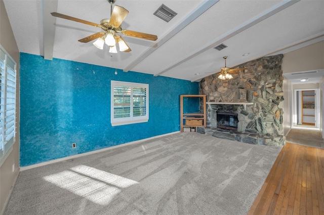 unfurnished living room with ceiling fan, a fireplace, and vaulted ceiling with beams