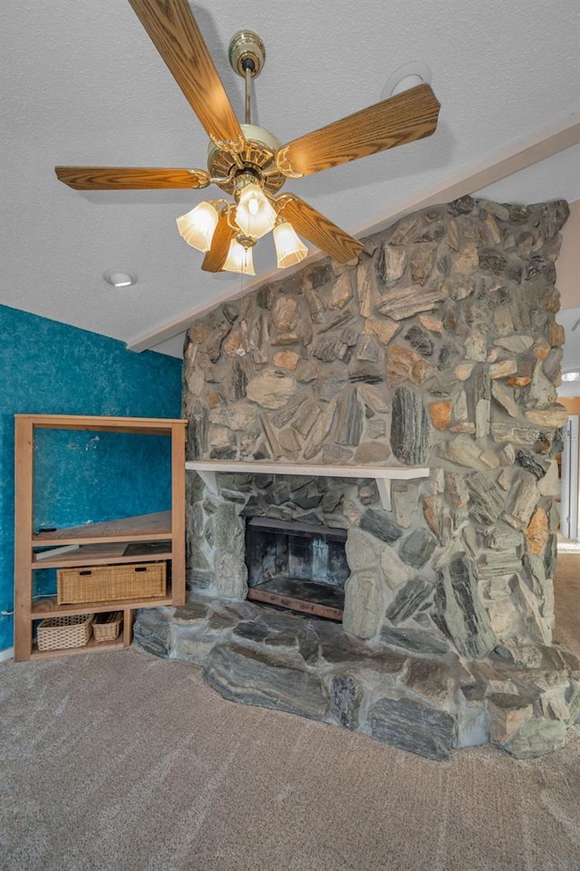 carpeted living room with ceiling fan, a fireplace, and a textured ceiling