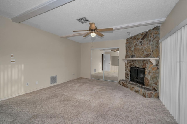 unfurnished living room featuring ceiling fan, a fireplace, a textured ceiling, and carpet flooring