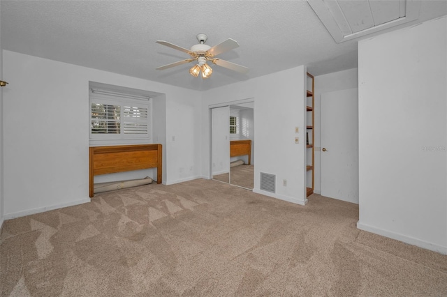 unfurnished bedroom featuring light colored carpet, a closet, and a textured ceiling