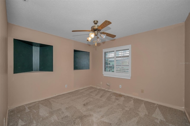 carpeted spare room with ceiling fan and a textured ceiling