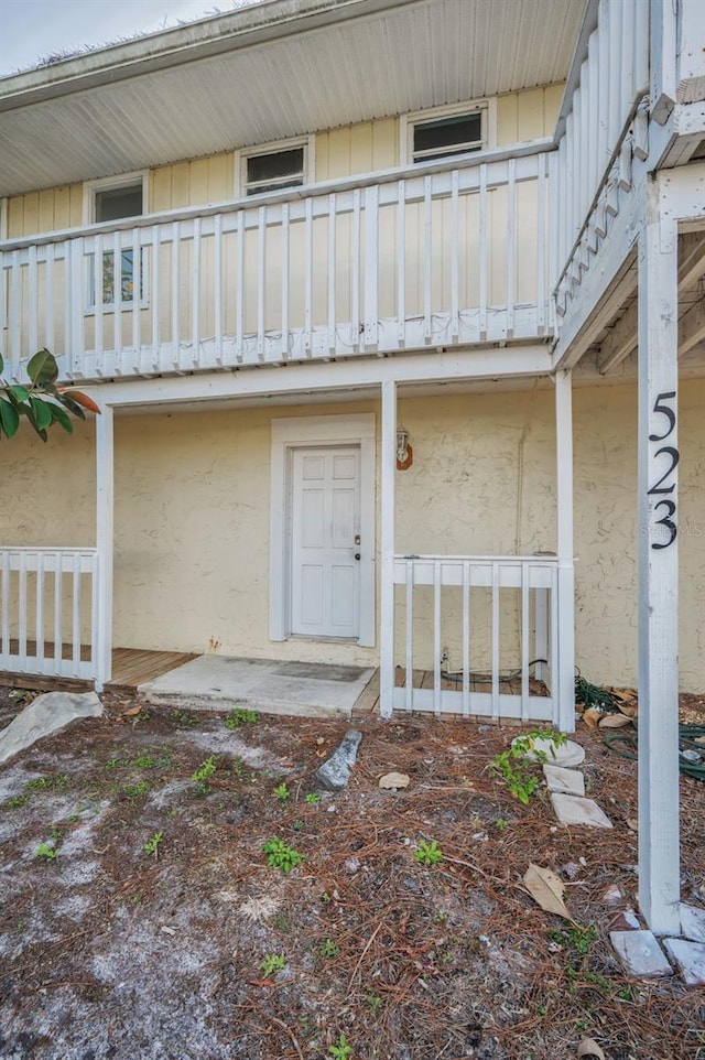 view of exterior entry with a balcony