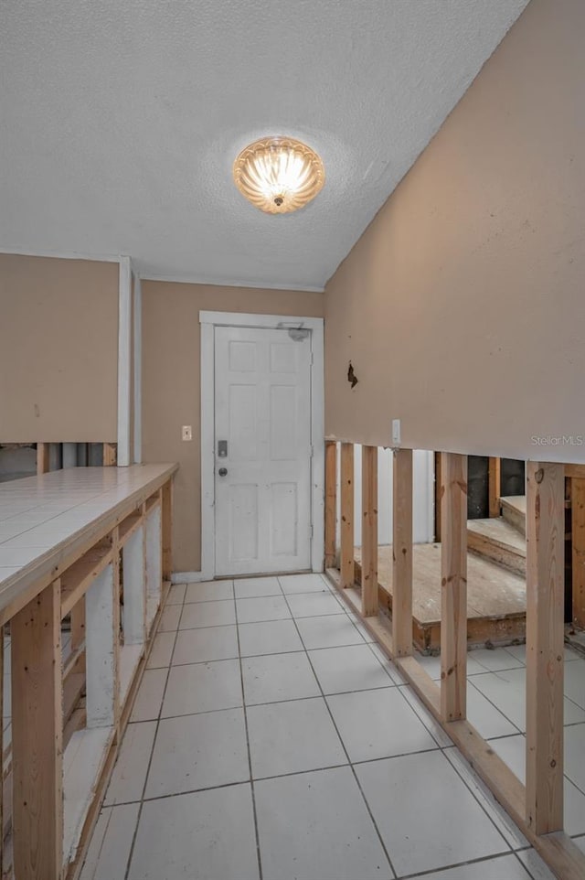 interior space with light tile patterned floors and a textured ceiling