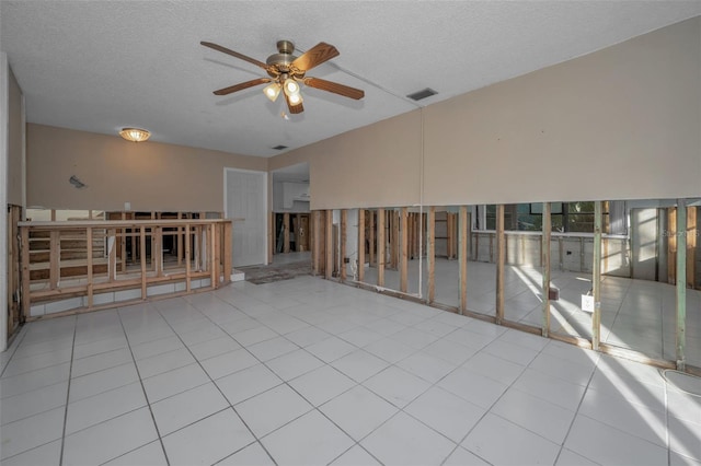 unfurnished room with light tile patterned floors, a textured ceiling, and ceiling fan