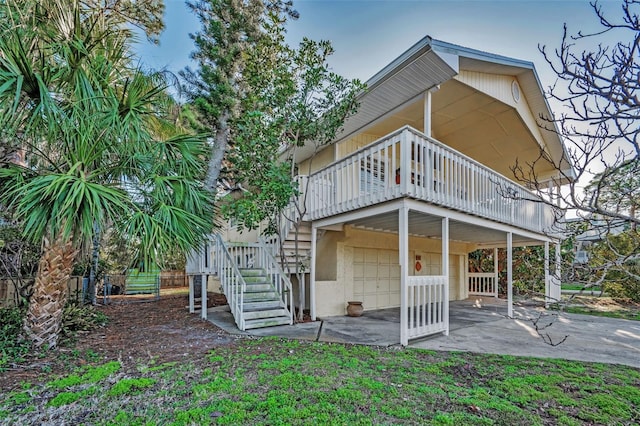 rear view of house featuring a deck and a patio area