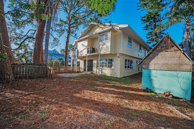 rear view of property with central AC and a balcony