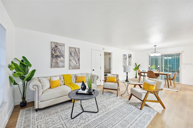 living room with an inviting chandelier and light wood-type flooring