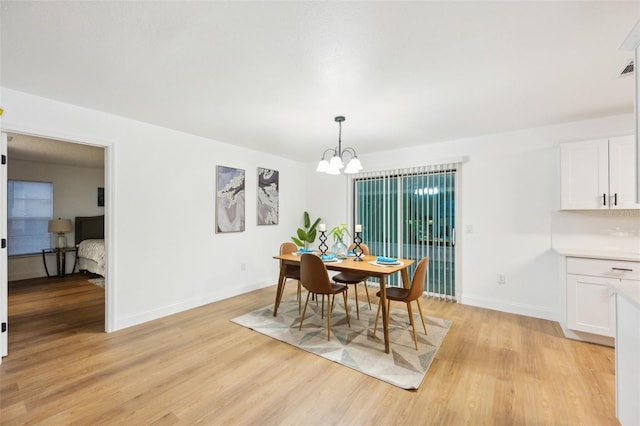 dining space featuring a chandelier and light wood-type flooring