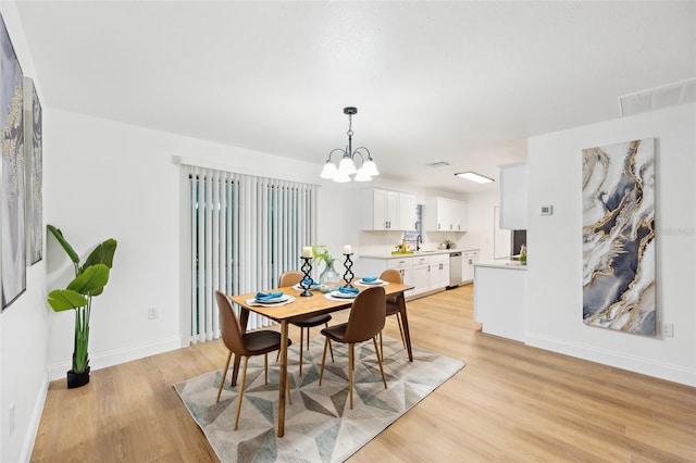 dining area featuring a chandelier and light wood-type flooring