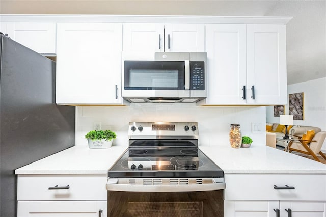 kitchen with tasteful backsplash, white cabinetry, and appliances with stainless steel finishes