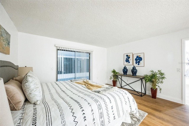 bedroom featuring light hardwood / wood-style floors and a textured ceiling