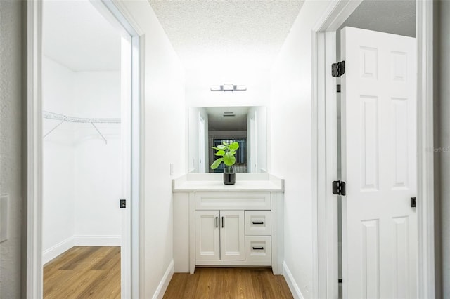 bathroom featuring vanity, hardwood / wood-style floors, and a textured ceiling