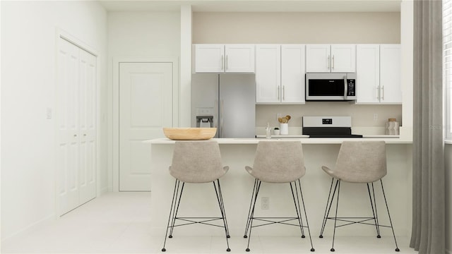 kitchen with white cabinetry, appliances with stainless steel finishes, and a kitchen bar