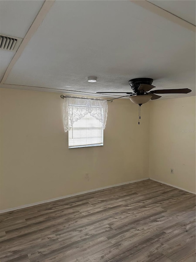 empty room featuring wood-type flooring, a textured ceiling, and ceiling fan