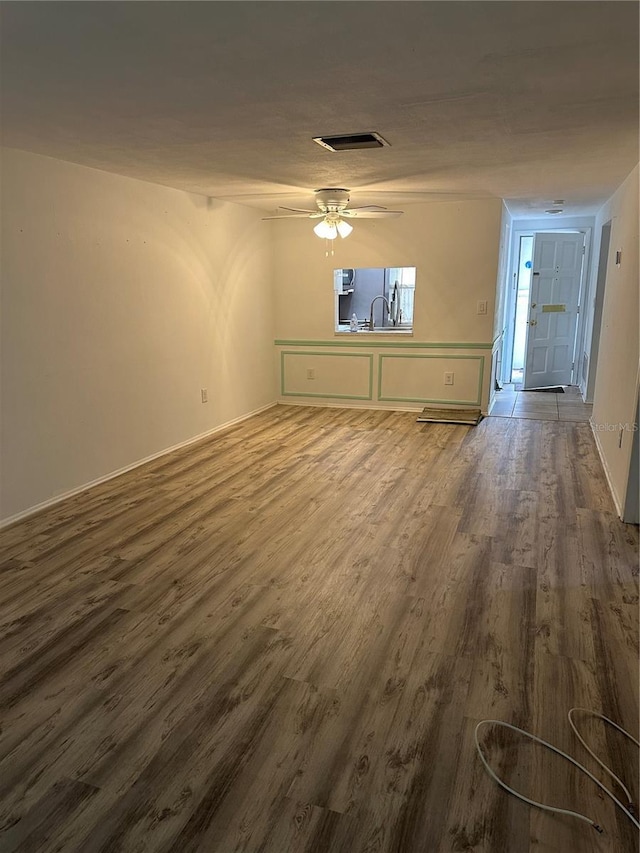 unfurnished living room featuring wood-type flooring and ceiling fan